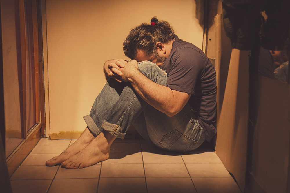 Depressed Man Sitting in Corner